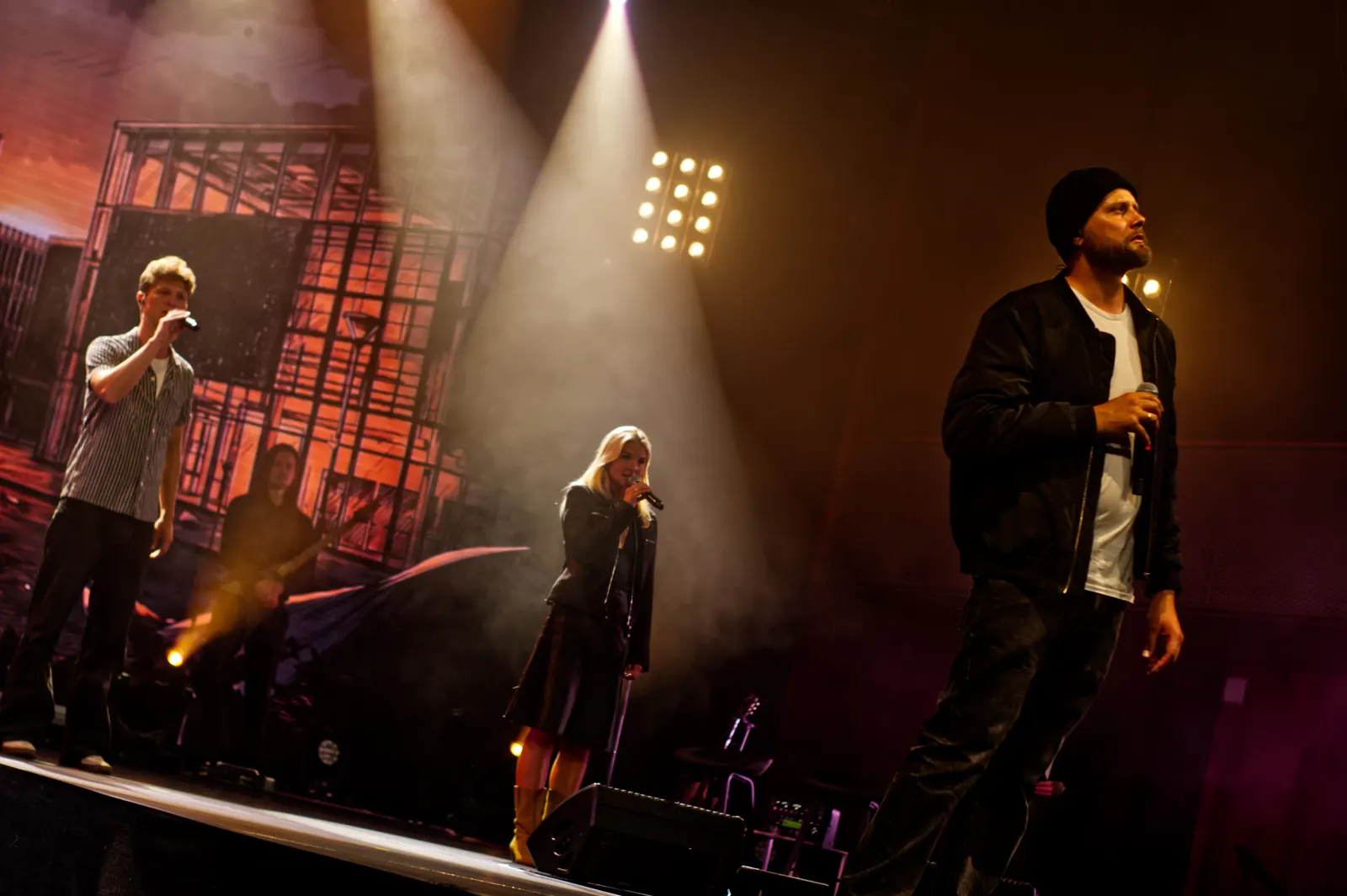 The ensemble on stage under a sky of light